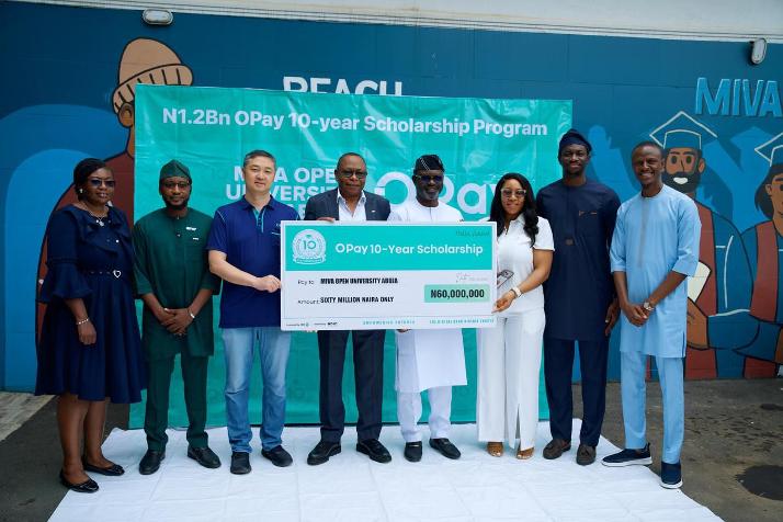 OPay representatives holding scholarship cards during a scholarship programme presentation